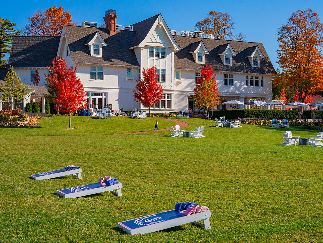 a large white building with lawn chairs and benches in front of it