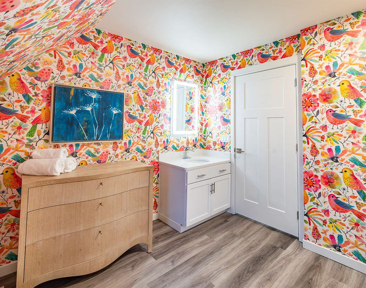 Bathroom with colorful bird wallpaper and vanity at The Inn at Stonecliffe, a standout among Mackinac Island hotels.
