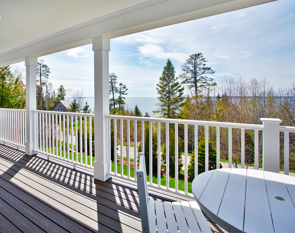 Covered porch with water and bridge views at The Inn at Stonecliffe, one of the scenic Mackinac Island hotels.