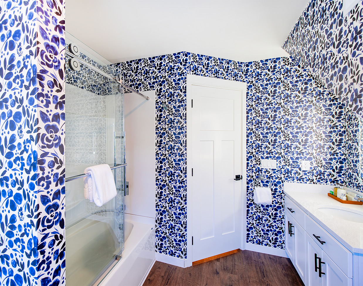 Suite bathroom with blue floral wallpaper and glass shower at The Inn at Stonecliffe, one of the refined Mackinac Island hotels.
