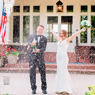 a bride and groom opening a bottle of champagne