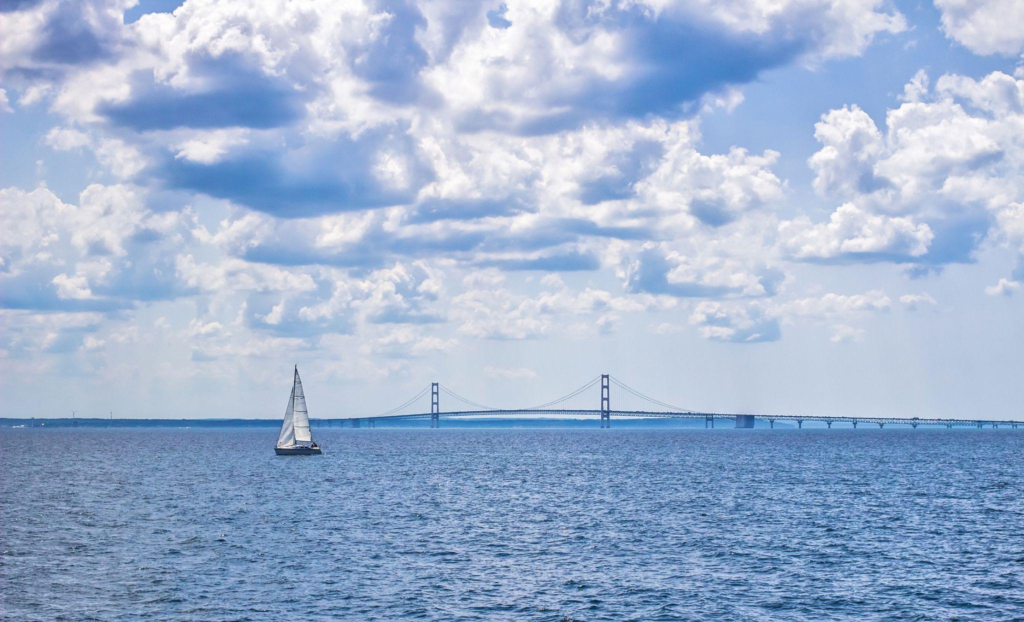 Windy Escapes Charters sailing yacht on the Straits of Mackinac near Mackinac Island with views of Mackinac Bridge and the shoreline near The Inn at Stonecliffe