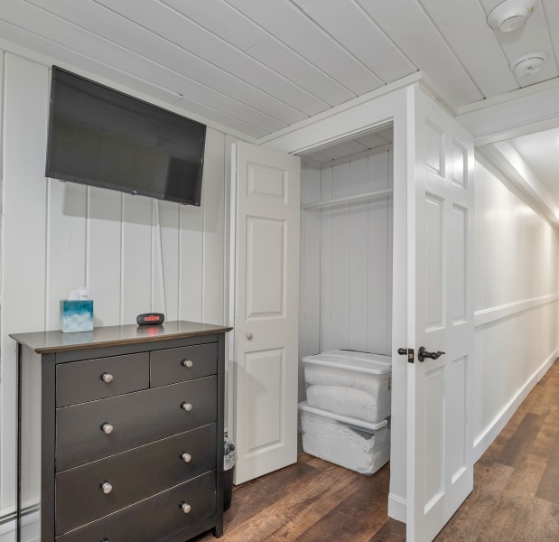 a room with white walls and a dresser