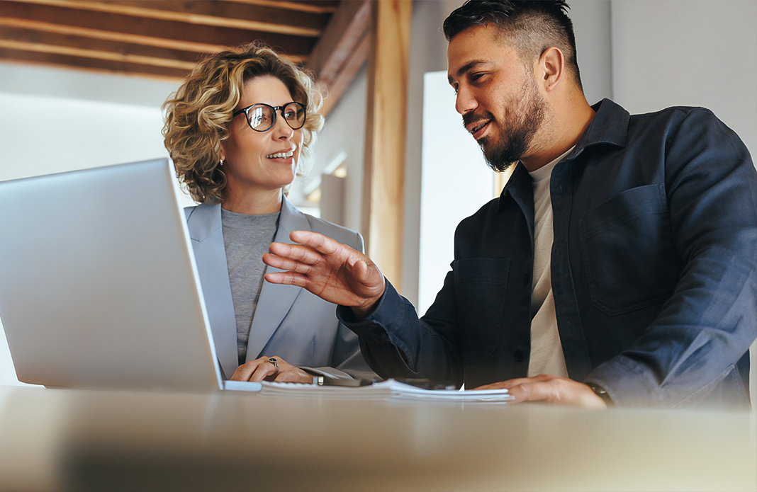 a man and woman looking at a laptop