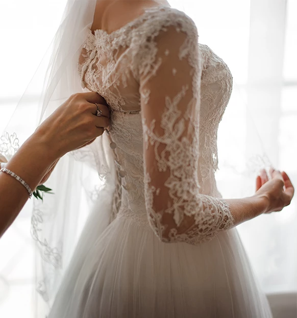 a person putting on a wedding dress