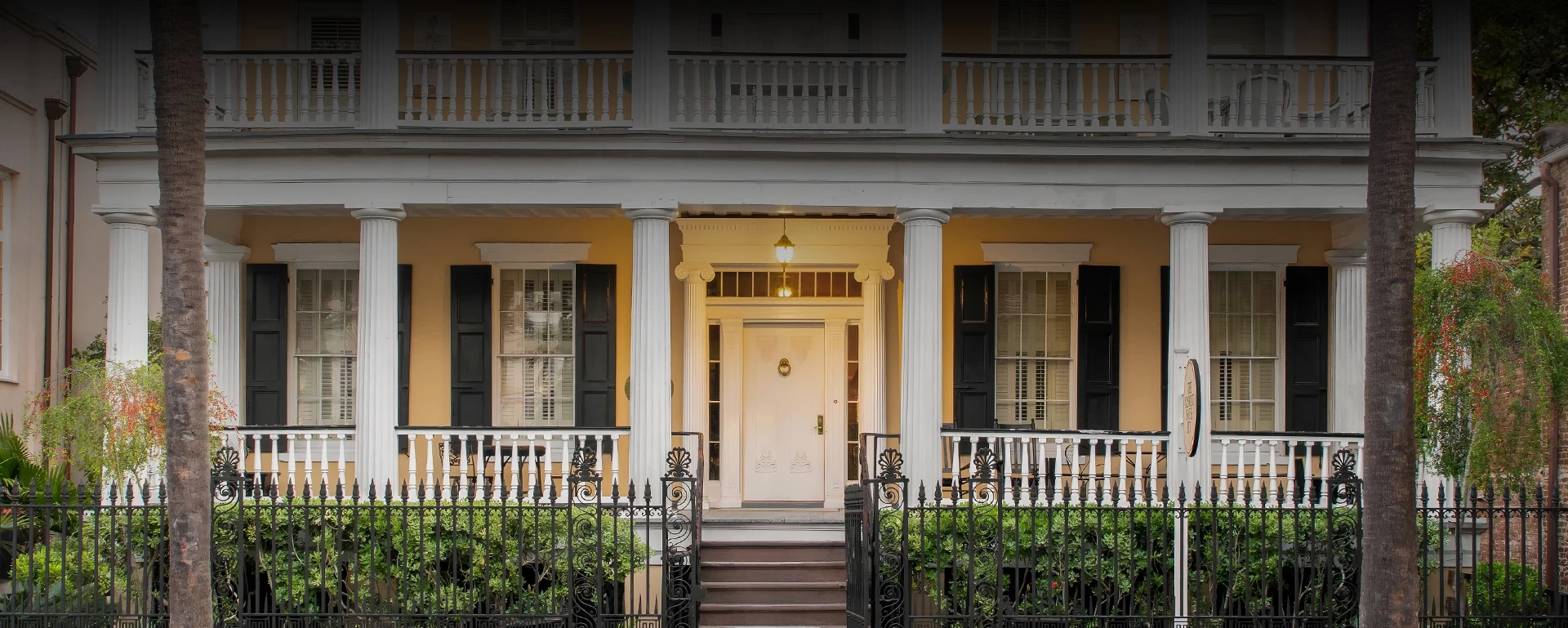 a front view of a house with a white door and black shutters