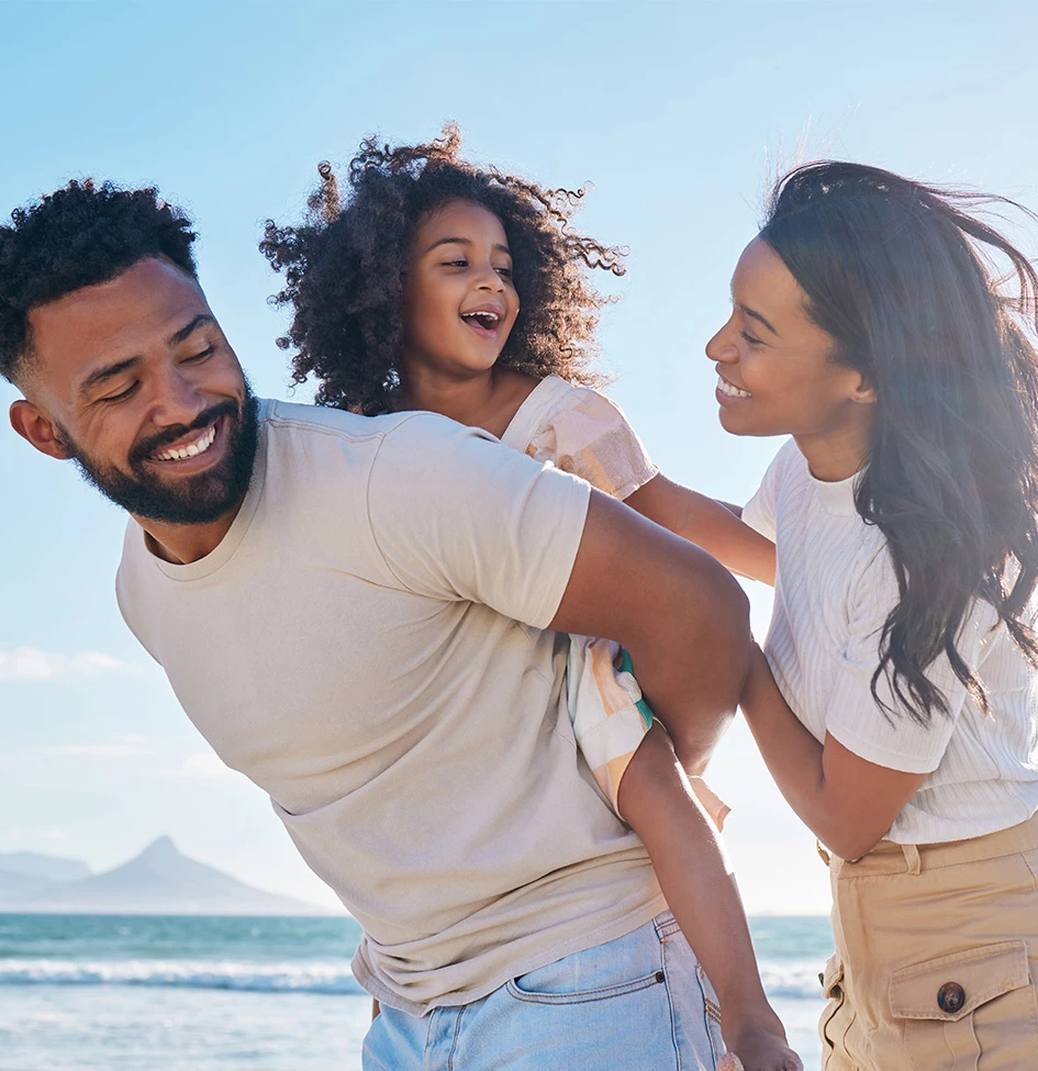 a man, woman and child on the beach