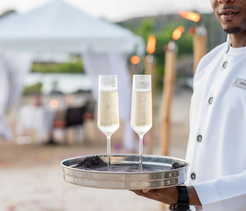 a man holding a couple of wine glasses