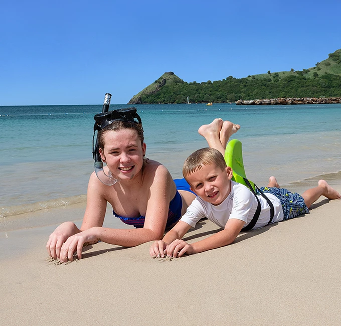 a girl and a boy lying on the beach