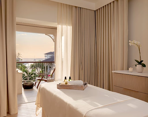 a massage table in a room with a balcony and a view of the ocean