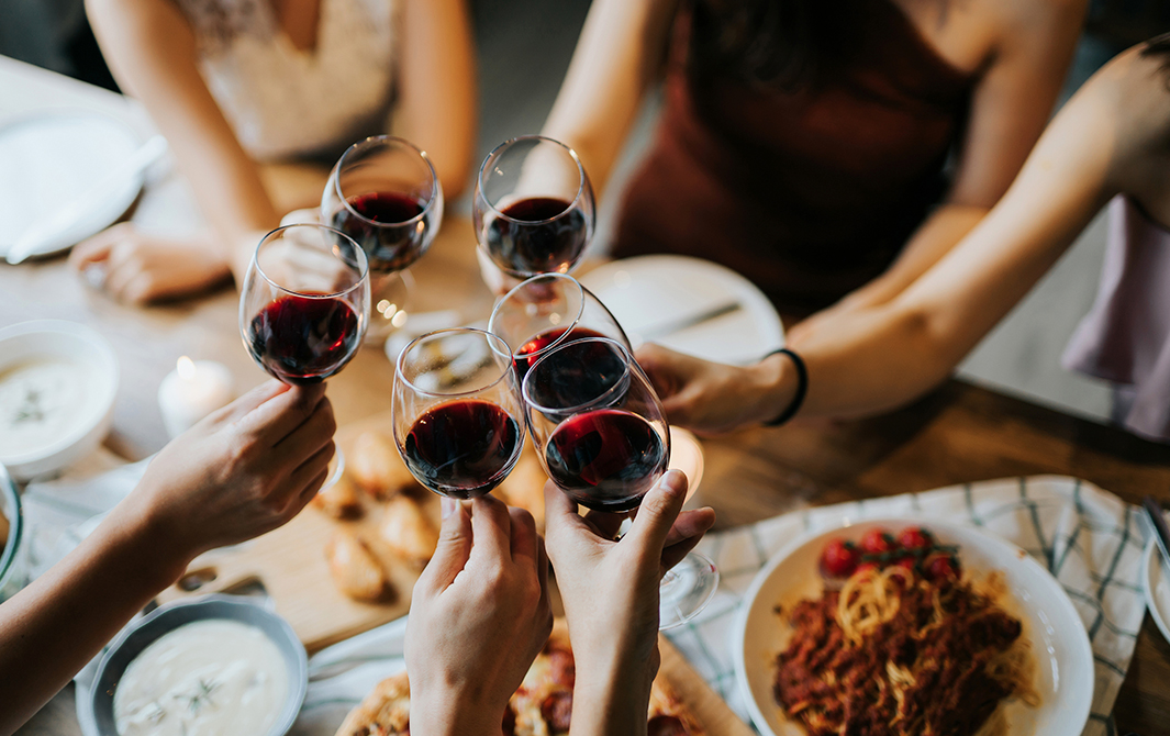 people are eating pizza and drinking wine