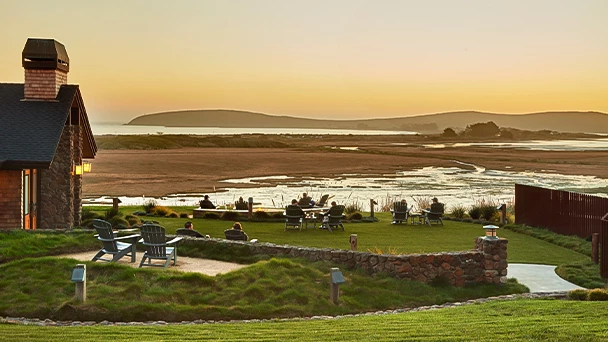 a group of people sitting at a table in a field