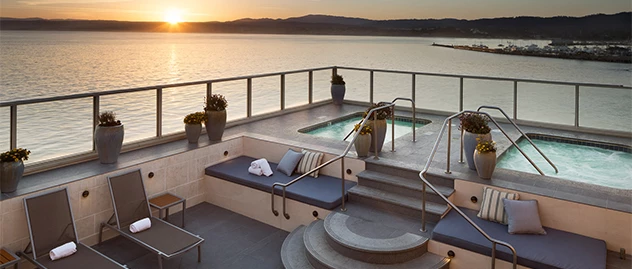 a pool with a hot tub and a bench on a deck