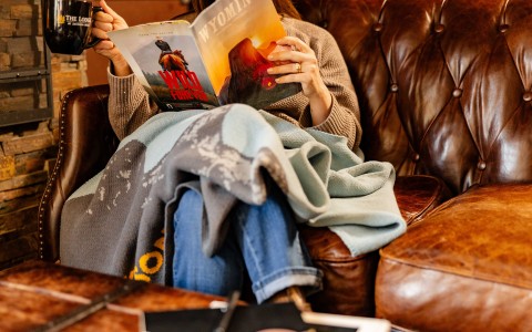 a person sitting on a couch reading a book