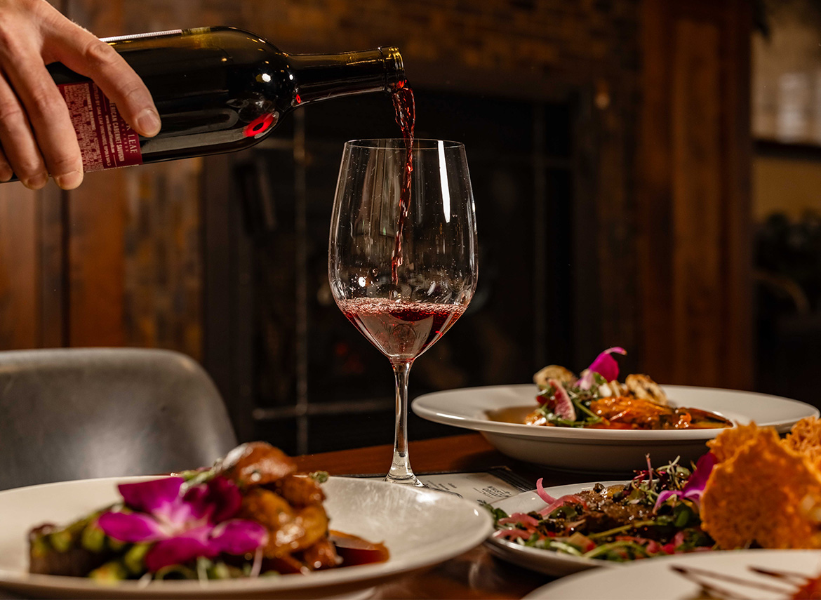 a person pouring wine into a glass