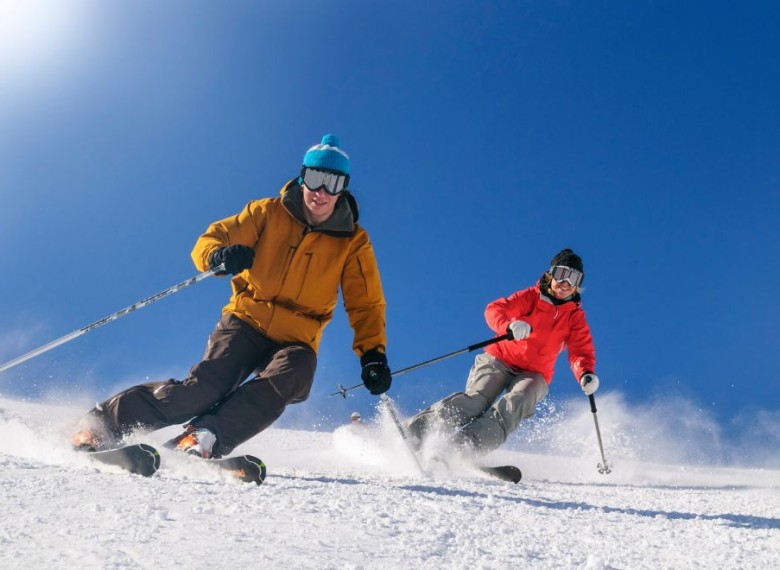 a couple of people skiing on snow
