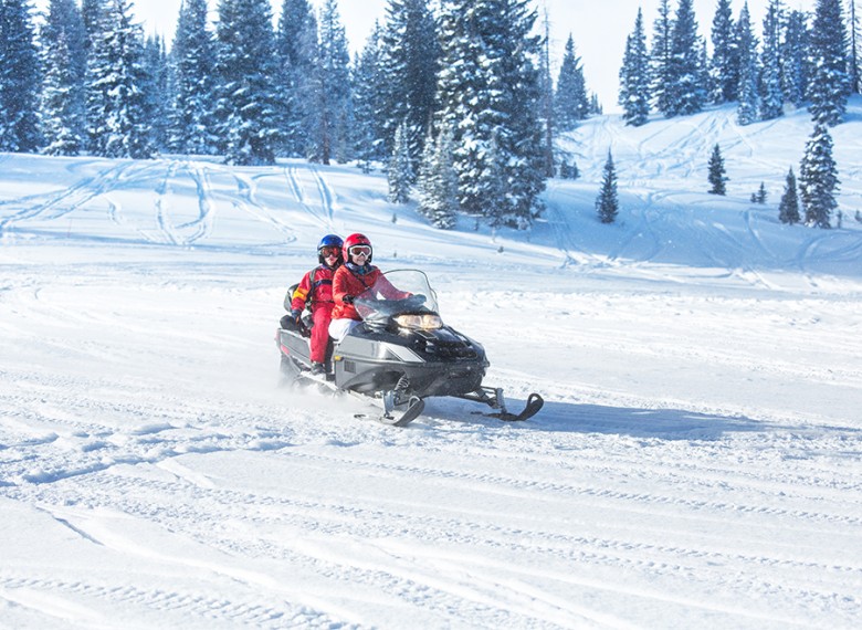 people on a snowmobile in the snow