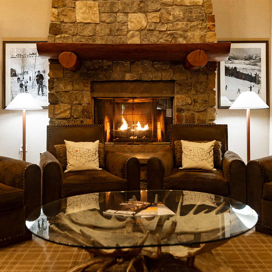 a fireplace with a glass table and chairs