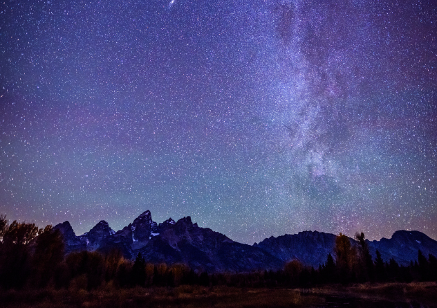 a starry night sky over a mountain range