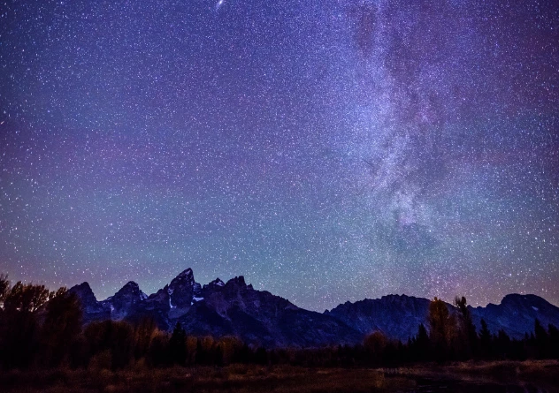 a starry night sky over a mountain range