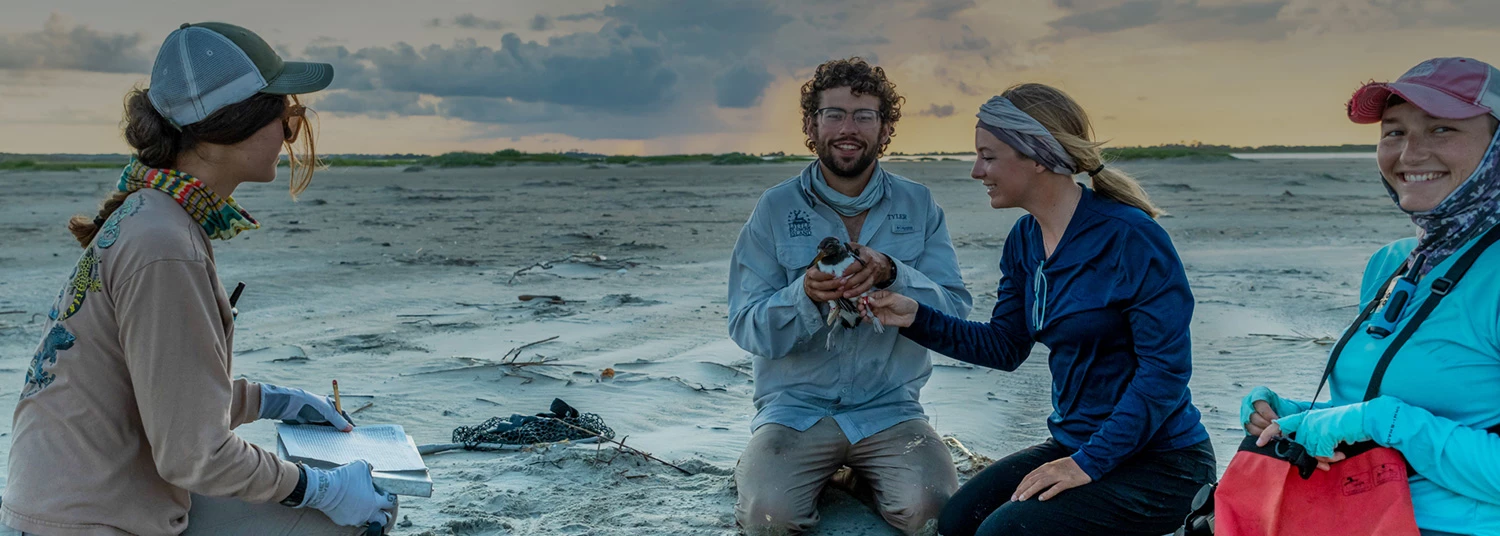 a man holding a bird while people sit around him