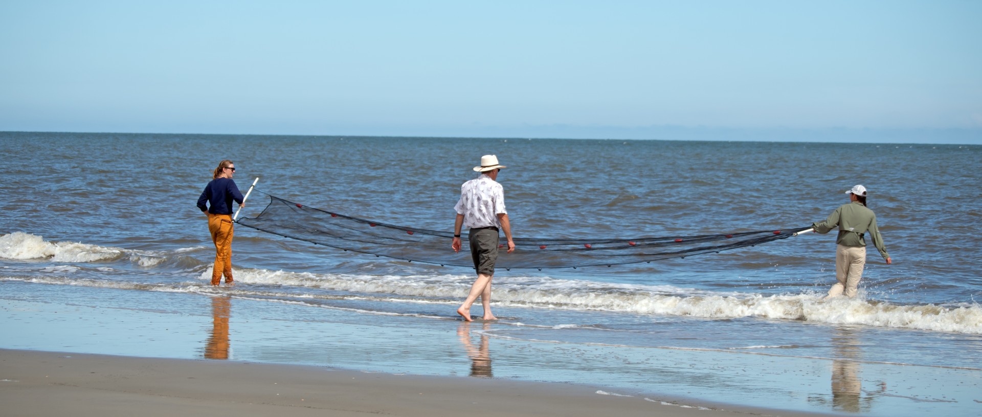 a man walking on a beach with a net
