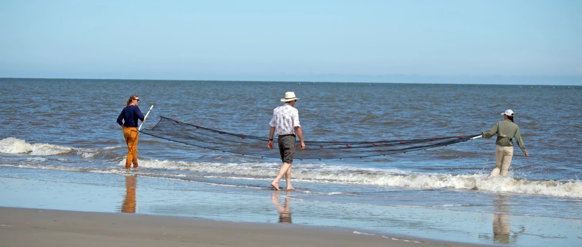 a man walking on a beach with a net