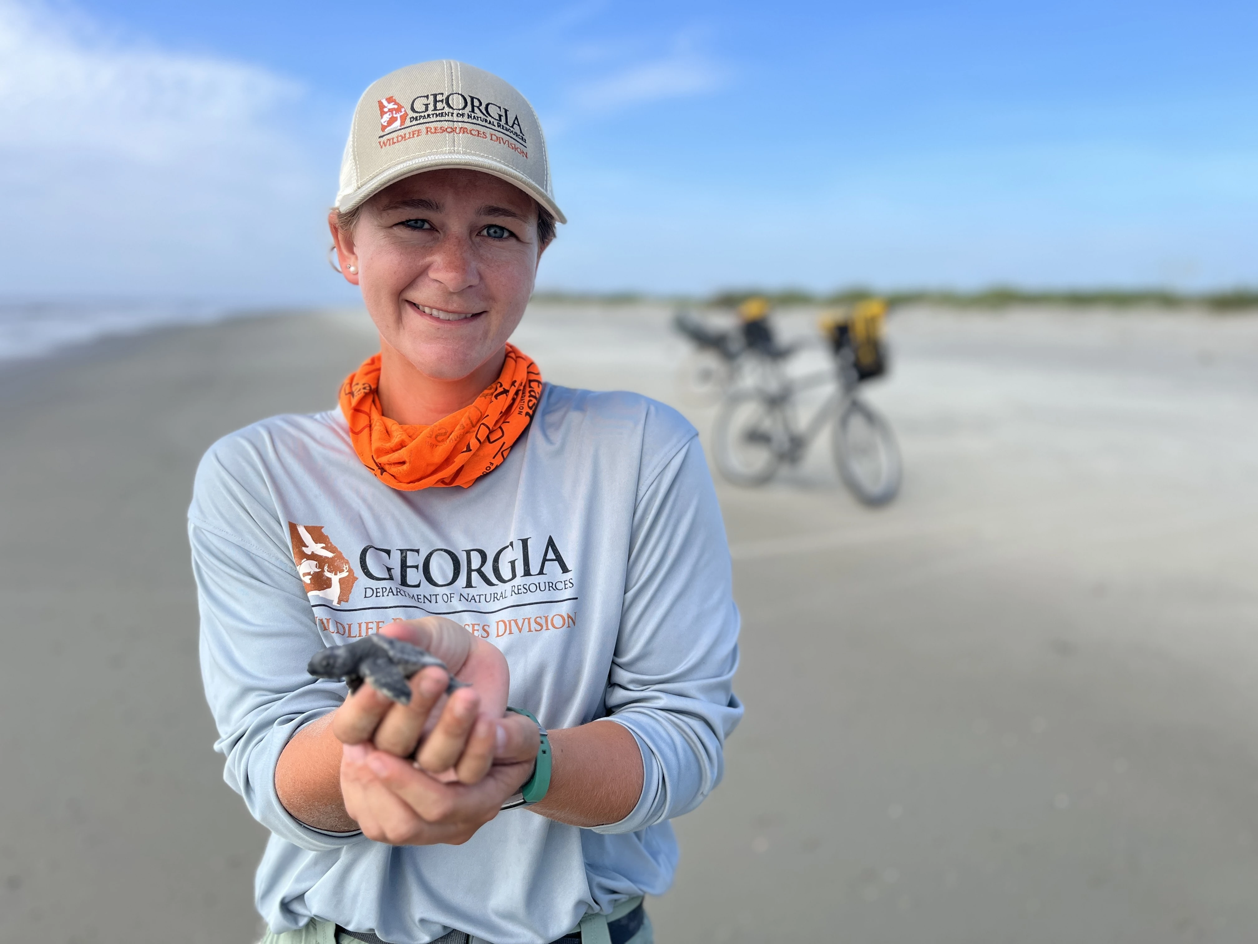 a woman holding a small turtle