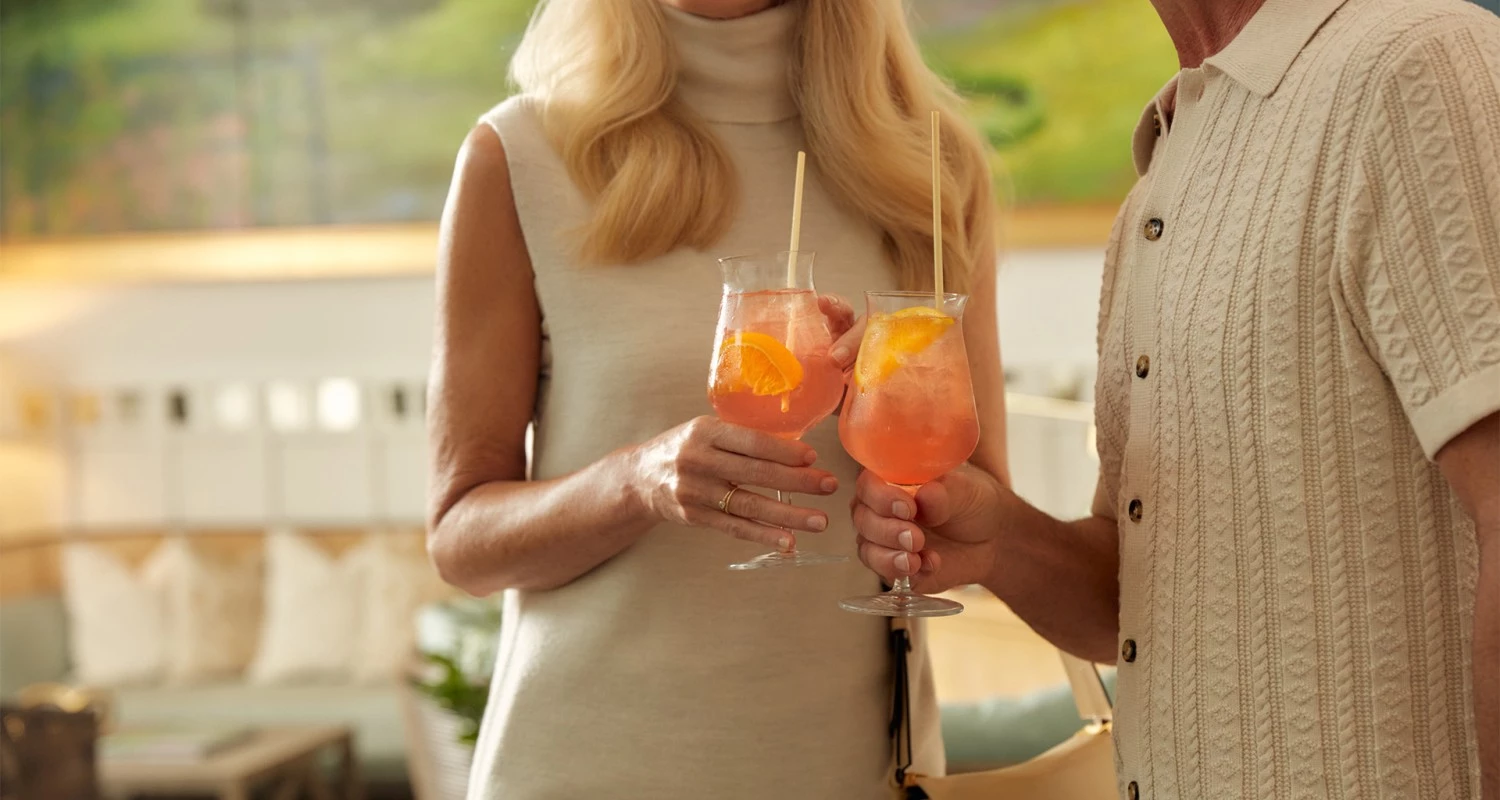 a woman holding two glasses of drinks