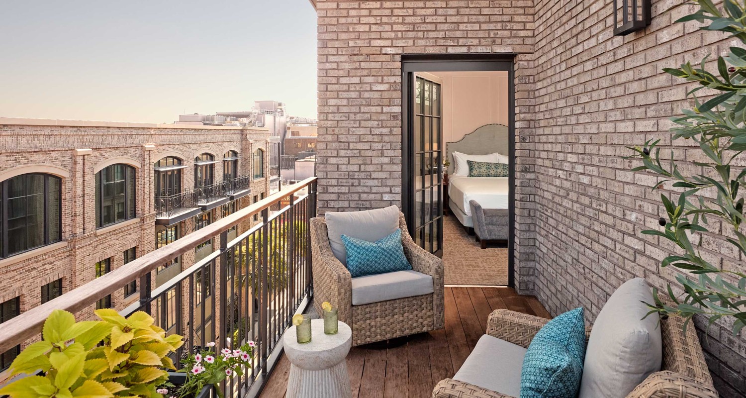 a patio with chairs and a table on a brick building