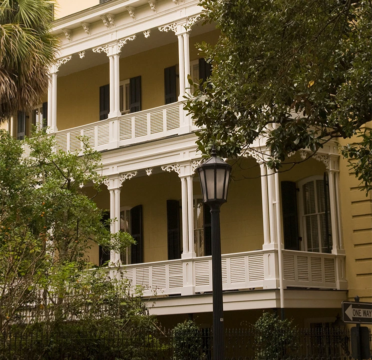 A yellow building with white columns and balconies