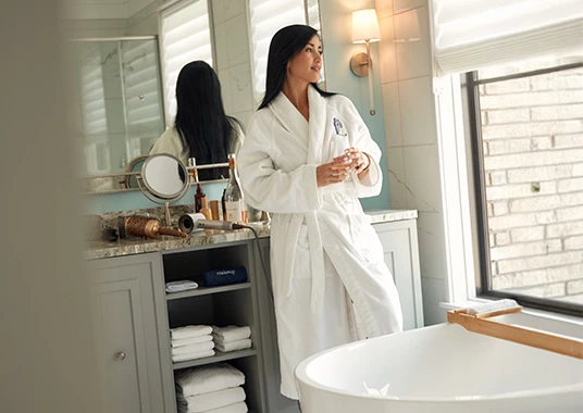a woman in a white robe in a bathroom