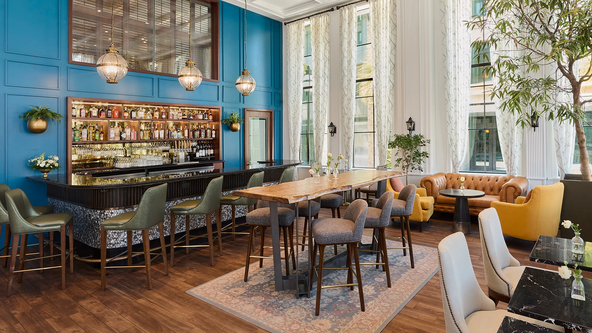 A lounge with a bar, seating area, and large windows.