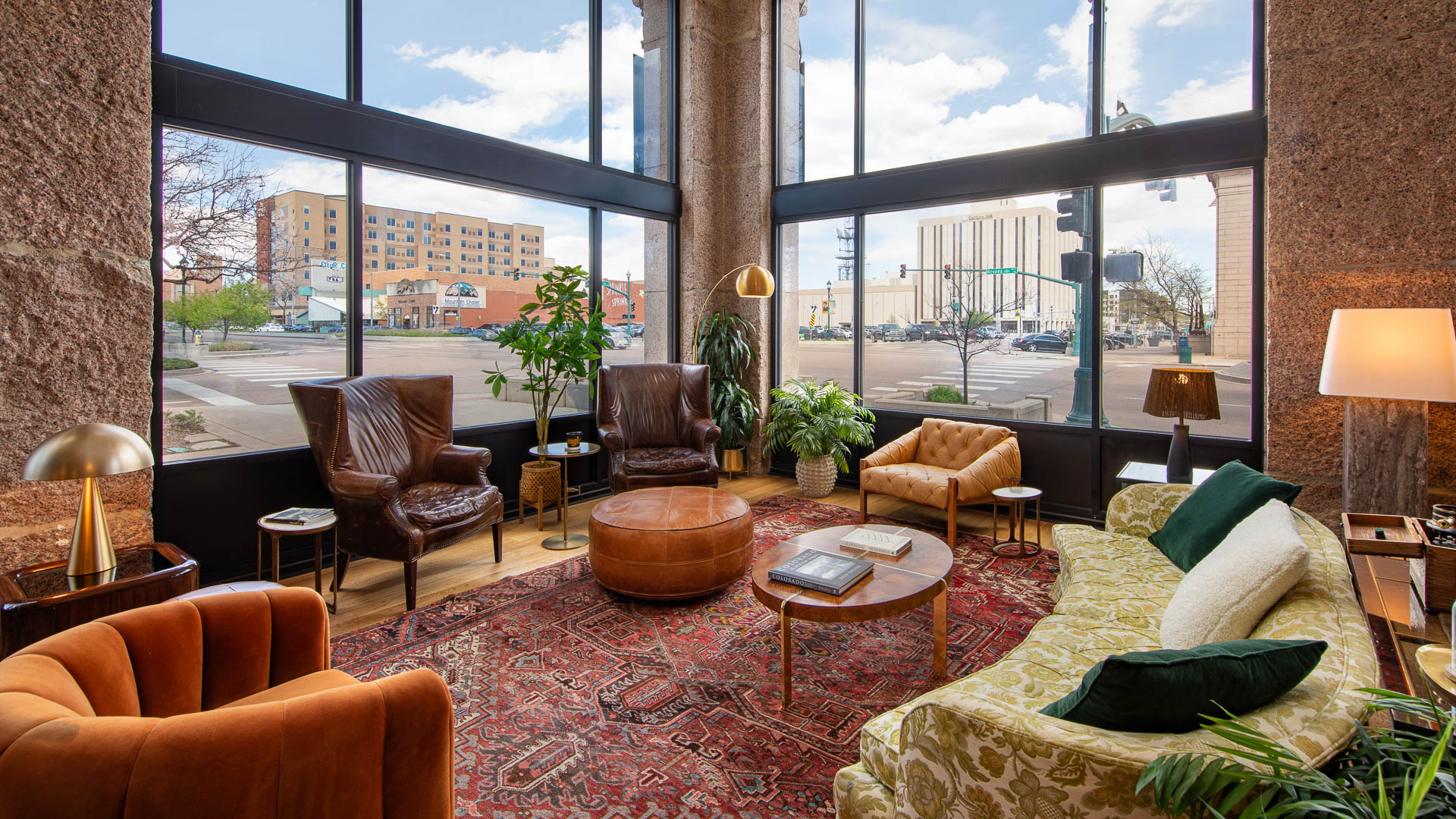 a room with a large window and a couch and chairs