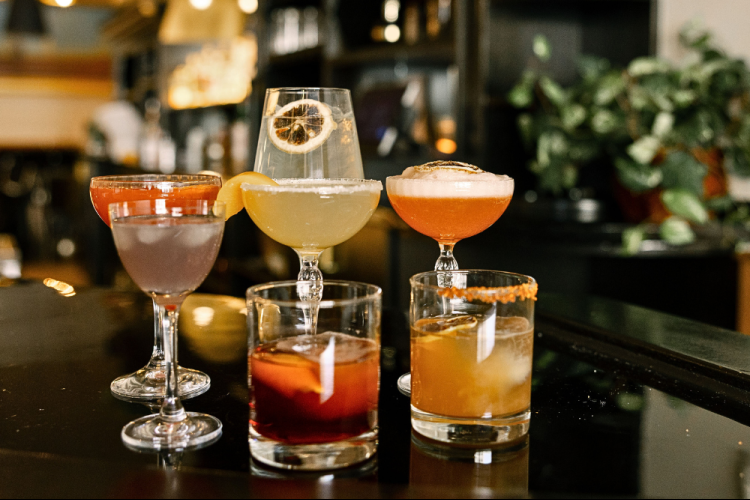 a group of glasses of different colored drinks
