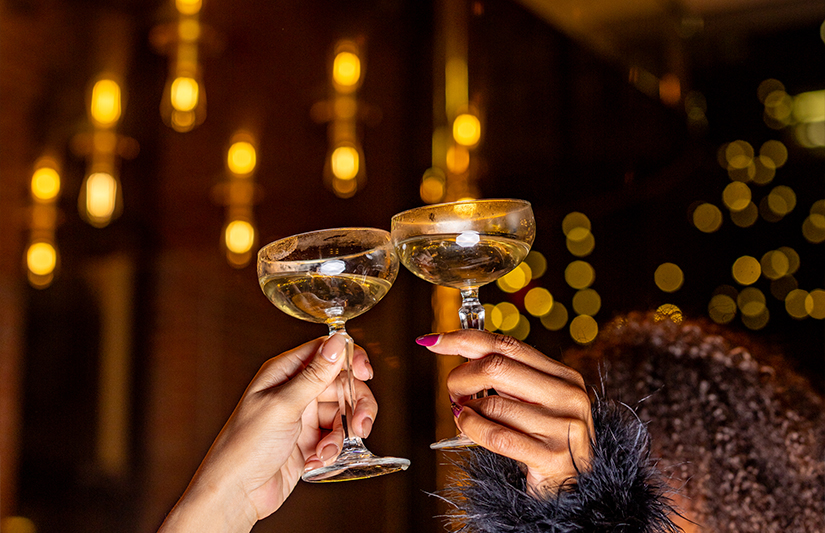 a pair of hands holding wine glasses