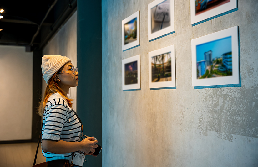 a woman looking at pictures on a wall
