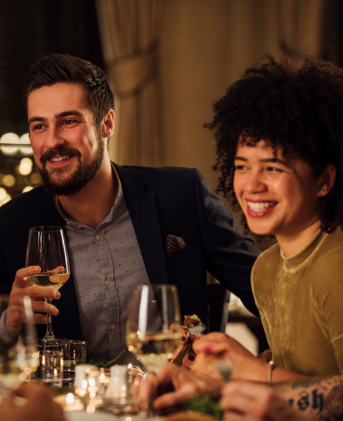 a man and woman sitting at a table with wine glasses