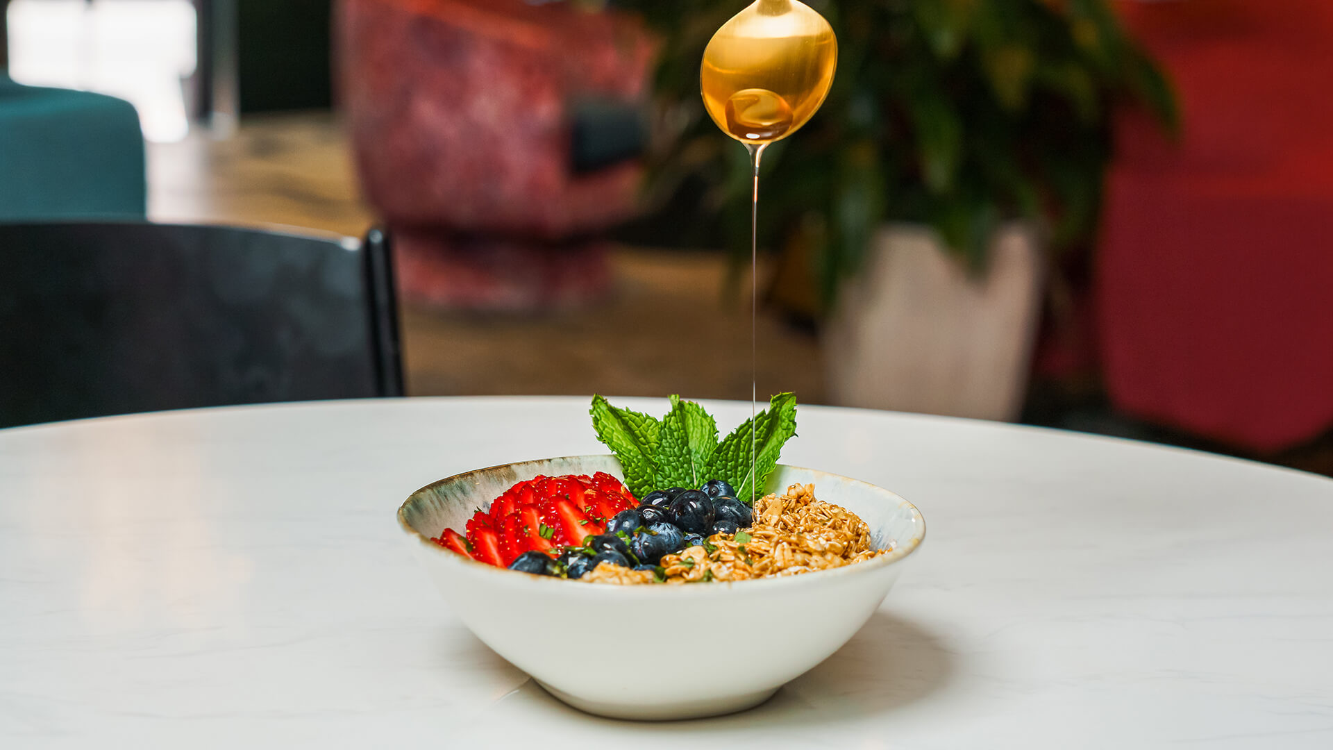 a bowl of food with a spoon and a drop of oil