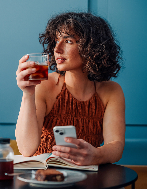 a woman holding a glass and a phone