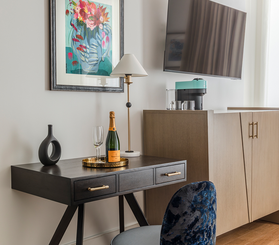 a table with a bottle of champagne on it and a lamp on the wall