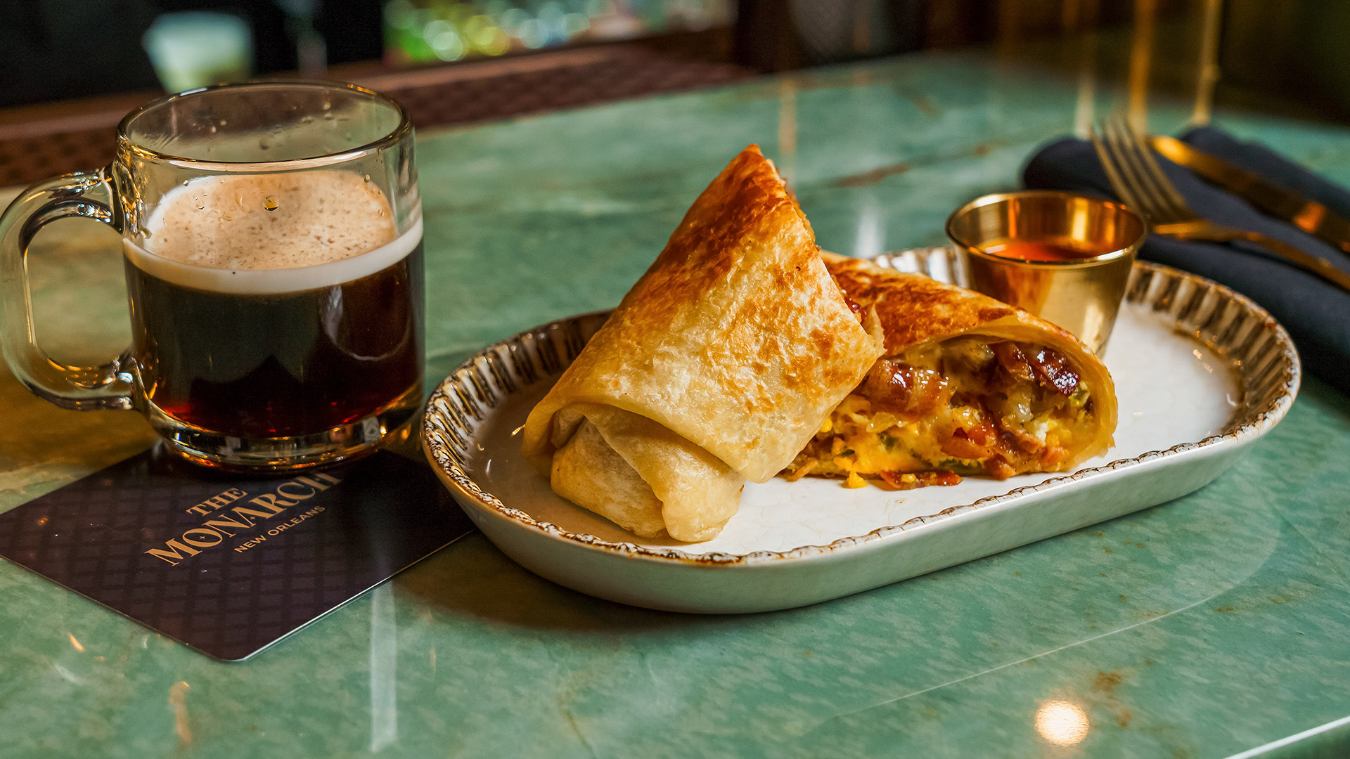 a burrito and a drink on a table