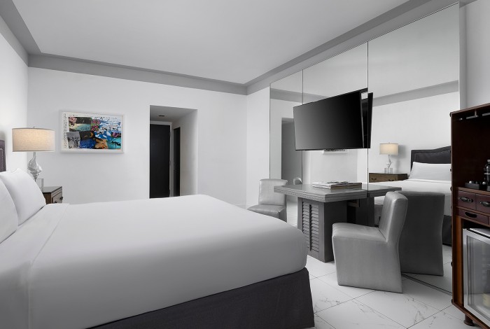 a room with a bed, table, chairs and tv
