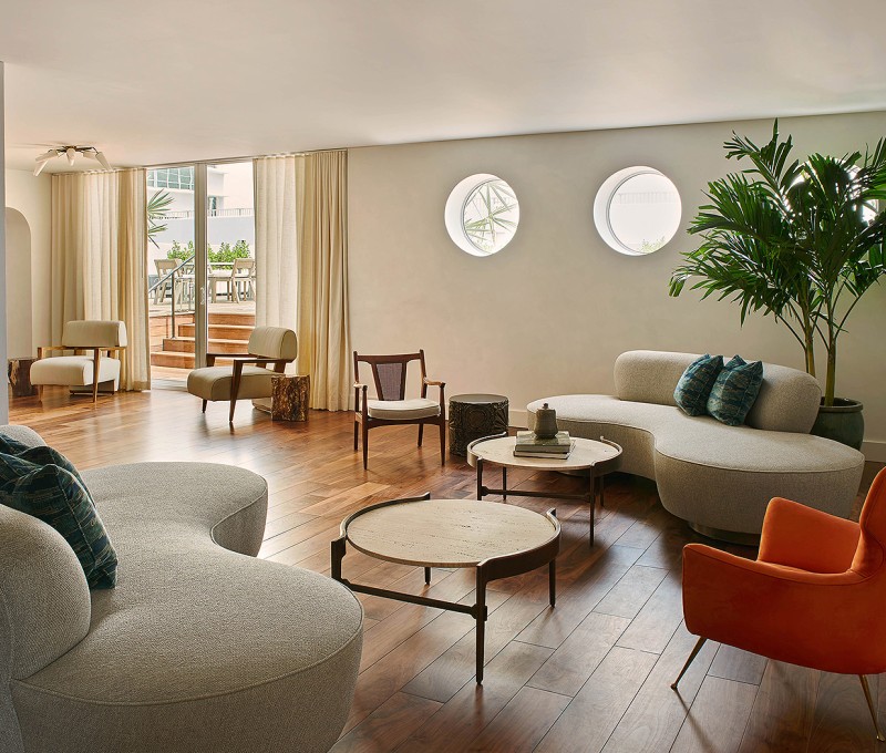 a living room with sofas, table and chairs