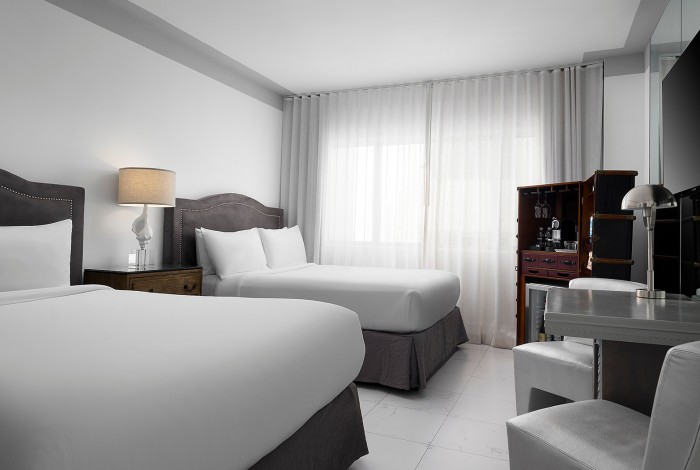 a bedroom with two beds and a nightstand in between