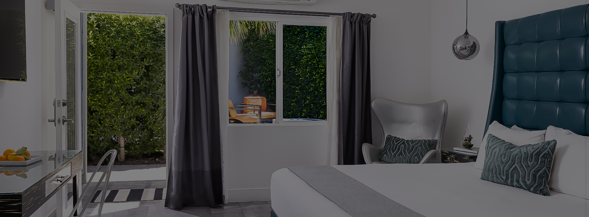A hotel room with a bed, chair, and window