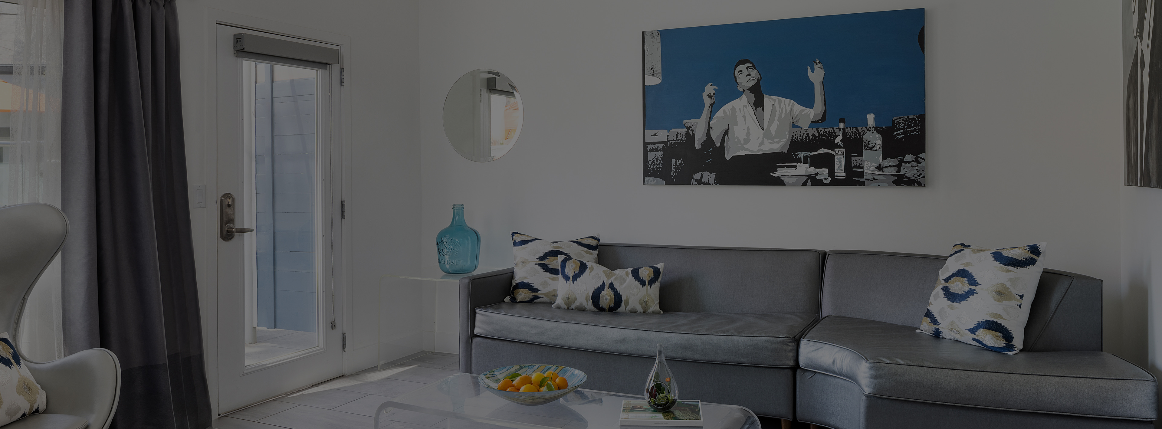 A hotel lobby with a gray sofa, coffee table, and artwork on the wall.