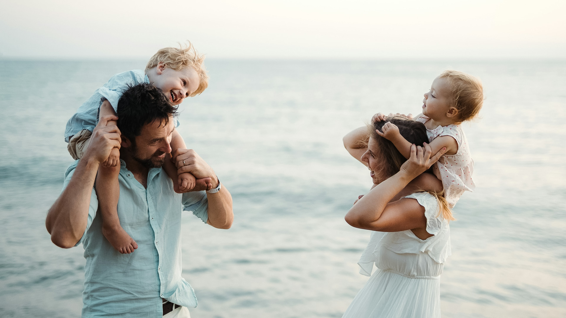 a man and woman with two children on their shoulders