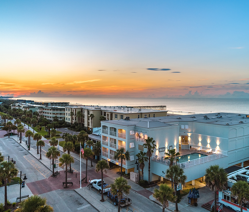 a street with palm trees and buildings by the ocean