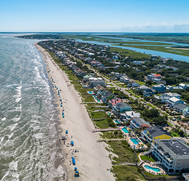 a beach with houses and a body of water